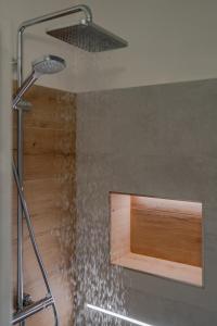 a shower with a shower head in a bathroom at Apartmány Stodola in Malá Morávka