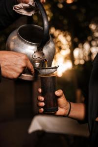 a person is holding a cup in their hands at Tupa Lodge Selva y Rio in Puerto Iguazú