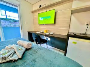 a bedroom with a bed and a tv on a wall at Executive - 106 No Garage in Caxias do Sul