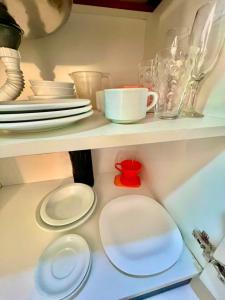 a shelf with plates and cups and dishes on it at Executive - 106 No Garage in Caxias do Sul +14 photos