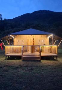 a large tent with two benches in front of it at Vjosa Valley Glamping in Tepelenë