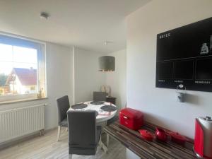 a room with a table with chairs and a television at Hochsitz Appartement in Seelitz