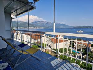 ein Balkon mit Stuhl und Blick aufs Wasser in der Unterkunft Carmen in Bijela
