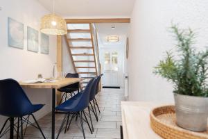 a dining room with a table and blue chairs at Huus 41 in Wulfen auf Fehmarn