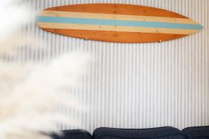 a surfboard hanging on a white wall at Huus 41 in Wulfen auf Fehmarn