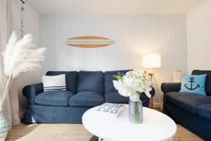 a living room with a blue couch and a table at Huus 41 in Wulfen auf Fehmarn