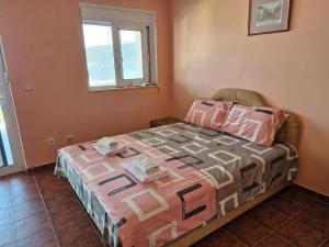 ein Schlafzimmer mit einem Bett, auf dem eine Steppdecke liegt in der Unterkunft Carmen in Bijela