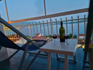 zwei Gläser Wein auf einem Tisch auf einem Balkon in der Unterkunft Carmen in Bijela