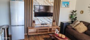 a living room with a couch and a flat screen tv at Elim Rest Place in Fisherhaven