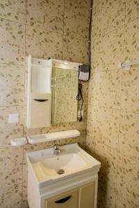 a bathroom with a white sink and a mirror at Khartoum Nights in Kigali