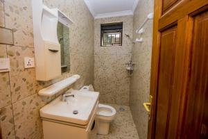 a small bathroom with a sink and a toilet at Khartoum Nights in Kigali