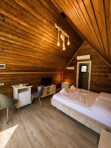 a bedroom with a large bed and a wooden ceiling at Koman Twin Cabins in Gushtë