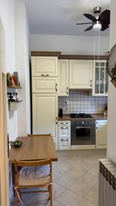 a kitchen with white cabinets and a wooden table at Little Paradise - charming apartment in Labin