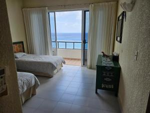 a bedroom with two beds and a view of the ocean at Cantamar 401, huge condo , incredible views, Sargassum Free in Cozumel