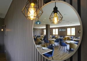 a mirror reflecting a dining room with tables and chairs at HOTEL Restaurante TurMo in Labuerda