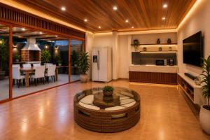 a large living room with a table and a kitchen at Mandinga Guest house in São Tomé