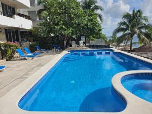 a swimming pool with blue water in a resort at Cantamar 401, huge condo , incredible views, Sargassum Free in Cozumel