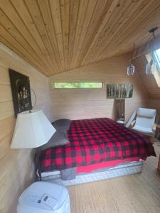 a bedroom with a bed in a log cabin at Hideaway from the Twin Cities in Houlton