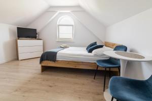 a bedroom with a bed and a table and chairs at Ada Niechorze in Niechorze