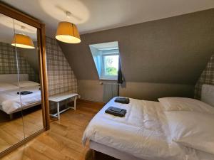 a bedroom with a white bed and a mirror at Le Clos des Argillières in Le Perrey