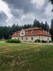 a large white house with a red roof at Dworek kwatery pracownicze in Kętrzyn