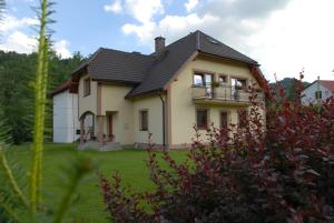 a yellow house with a balcony on a yard at Agroturystyka u Haliny in Kamesznica