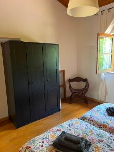 a bedroom with a green cabinet and a bed at Quinta dos Lagares in Espadanal