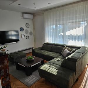 a living room with a couch and a table at Apartment & Rooms Majetic-Draskovic in Bizovac