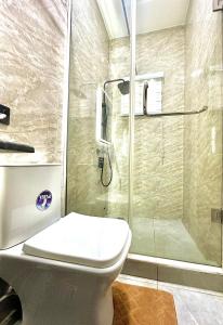 ein Badezimmer mit Dusche mit Toilette und Glasdusche in der Unterkunft Opic Shortlets in Agege