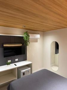 a bedroom with a bed and a tv and a ceiling at Vista do Pico in Fernando de Noronha