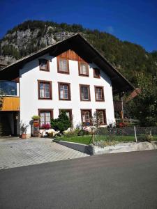 a white building with a mountain in the background at Big 3-bedroom flat with new kitchen in Brienz