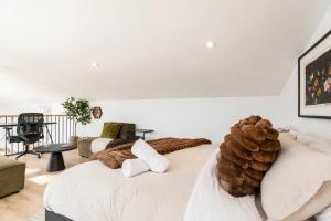 a bedroom with a white bed with a large pile of logs at Modern Comfort - Spa - Mountain - Chalet KNOX in Saint Come +29 photos