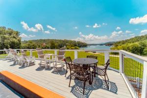 a deck with a table and chairs and a view of a lake at Deerfield Inn - Virtual Check In in Hayesville