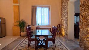 a dining room with a glass table and chairs at Casa Näab Centro de Merida in Mérida