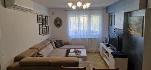 a living room with a couch and a television at Apartment Plava Voda in Travnik