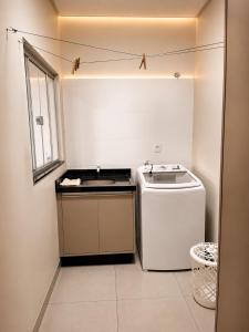 a small kitchen with a stove and a sink at Vêneto Flat Residence (AP-13) in Primavera do Leste
