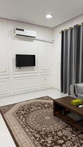 a white living room with a tv and a couch at شقه مستقله بالقرب من مطار صلاله in Salalah