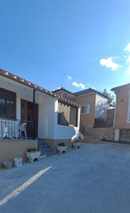 a white house with a driveway in a yard at Vila Nakaj Guest House in Gjirokastër