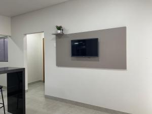 a wall with a tv on a white wall at Vêneto Flat Residence (AP-13) in Primavera do Leste