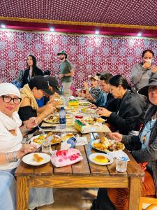 a group of people sitting around a table eating food at Norita Luxury Camp in Wadi Rum