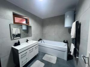 a bathroom with a white tub and a sink at Casa Angela in Râu de Mori