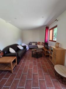 a living room with a couch and a table at Le ranch de Chant'alouette in Étauliers