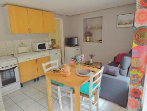 a kitchen and living room with a table and a dining room at Meublé des Capucins - Cocon & Terrasse Privée in Plombières-les-Bains