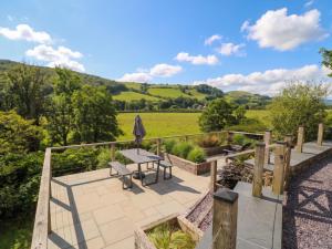 a patio with a table and an umbrella at Pengeulan in Machynlleth