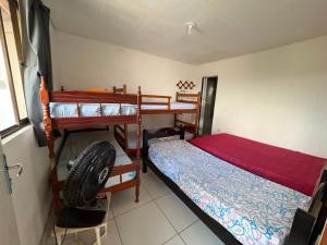a bedroom with two bunk beds and a fan at Casa de Temporada em Bezerros in Bezerros