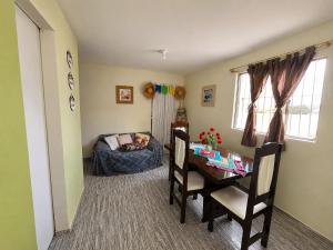 a room with a table and a dog sleeping on a couch at Casa de Temporada em Bezerros in Bezerros