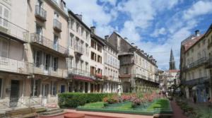a street in a city with buildings and flowers at Meublé des Capucins - Cocon & Terrasse Privée in Plombières-les-Bains