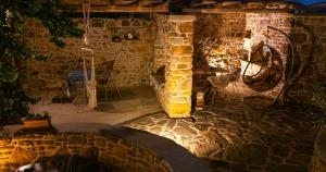 a stone fireplace in a room with a table and chairs at Rodakas Rooms-Adigoni in LivadhokhÃ³rion