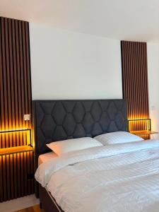 a bed with a black headboard in a bedroom at Salt Square Residence in Tuzla