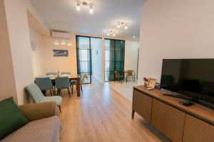 a living room with a television and a dining room at 3-Room Seaview Apartment at Bamboo Beach in Ts'ikhisdziri